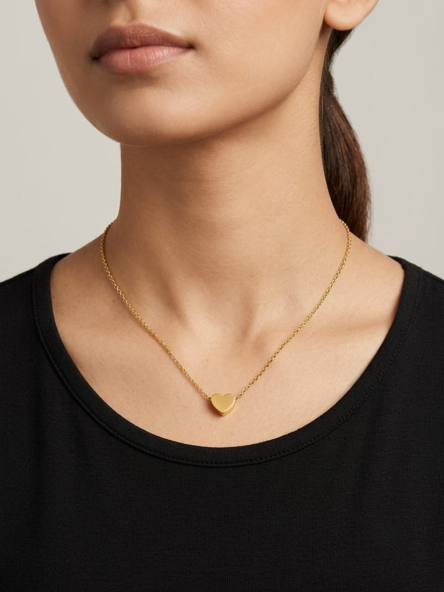 A woman is wearing our 18K Gold Finish Small Heart Pendant Chain Necklace
