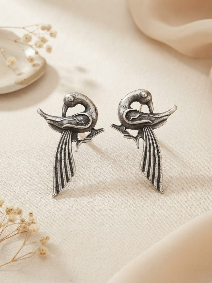 A pair of silver-toned bird stud earrings with long feather-like tails