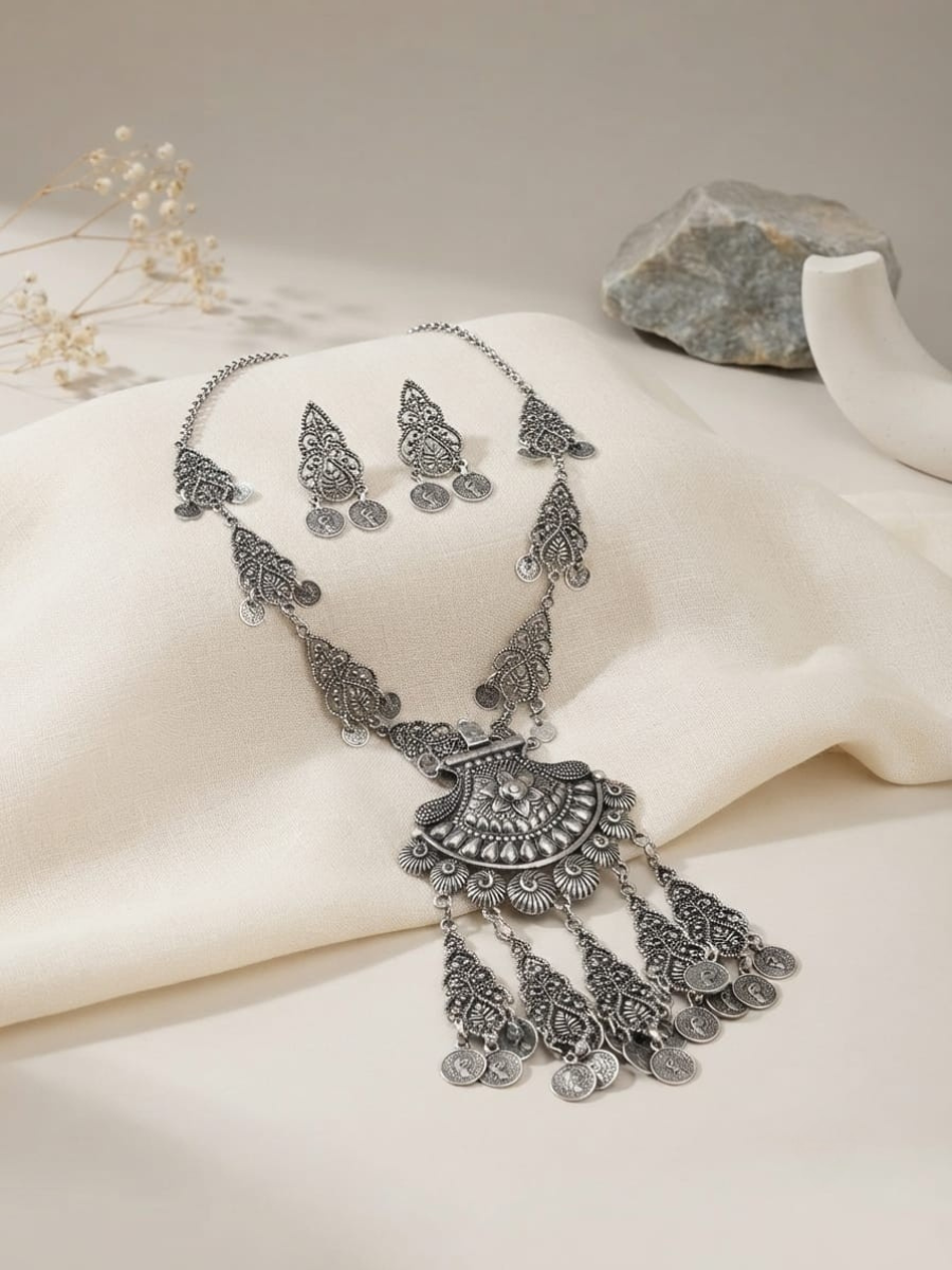 A necklace with a large filigree pendant and matching dangling earrings