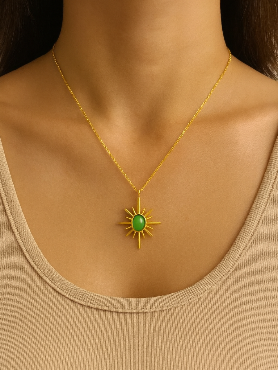 Gold necklace with a green sun charm pendant