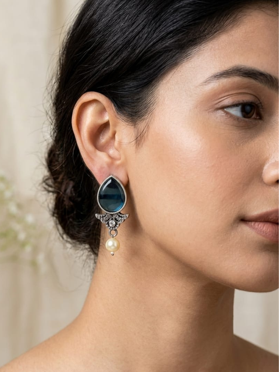 A model is wearing our Classic Blue Stone Studded Oxidised Silver Stud Earrings