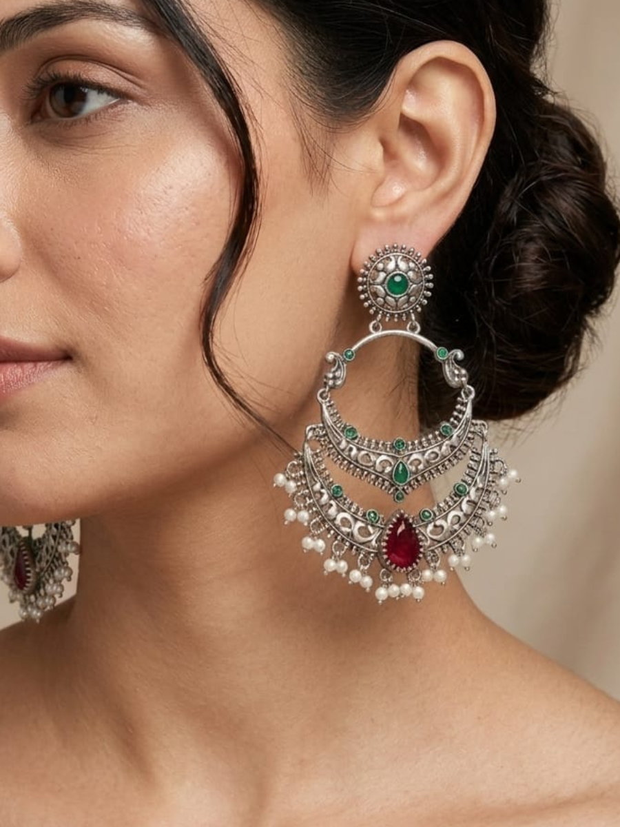 A model is wearing our Green and Ruby Red Stones German Silver Oxidised Chandbali Earrings