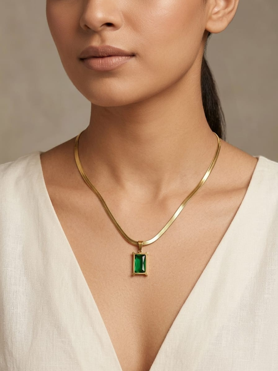 A woman is wearing our Luxury Emerald Green Stone Snake Chain Golden Necklace