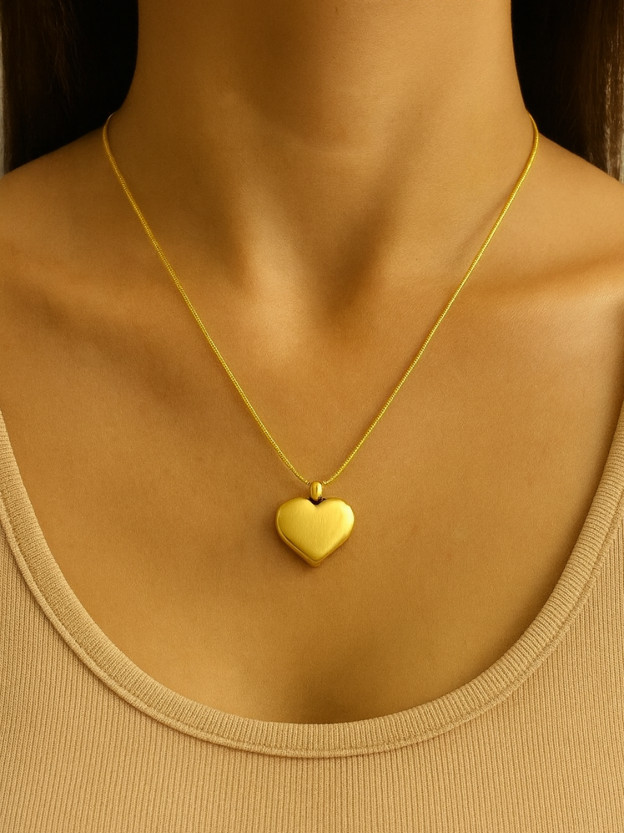 Gold heart-shaped pendant necklace on a woman.