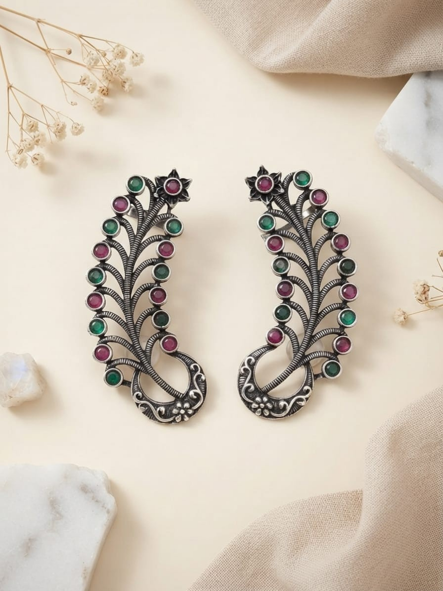 A pair of earcuff silver-toned leaf-shaped earrings decorated with alternating green and pink gemstones