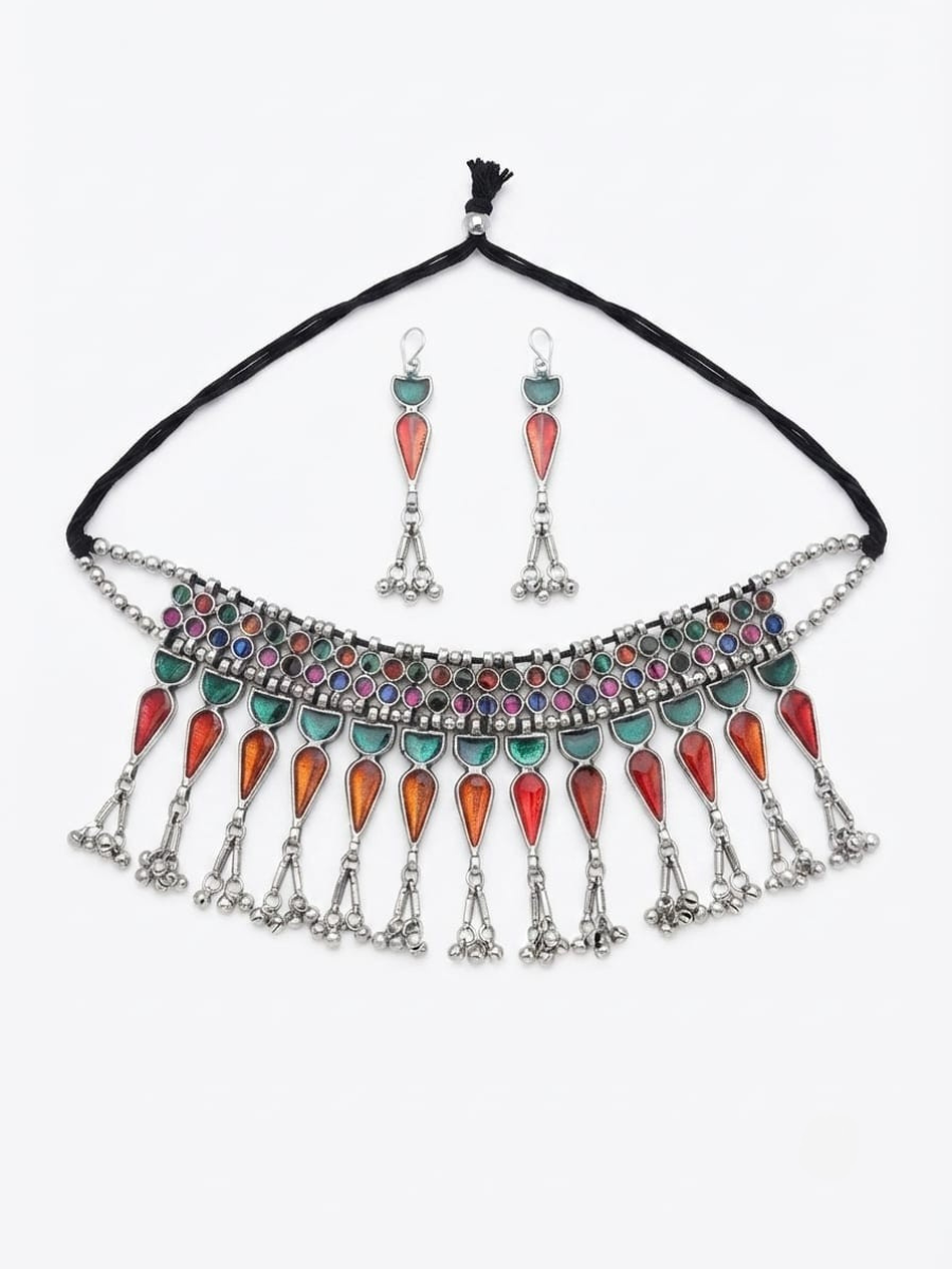 A bohemian-style silver necklace and matching drop earrings set. The necklace features a black cord, a silver-toned collar decorated with multicolored rhinestones, and dangling silver teardrop charms embellished with red, orange, and turquoise stones.