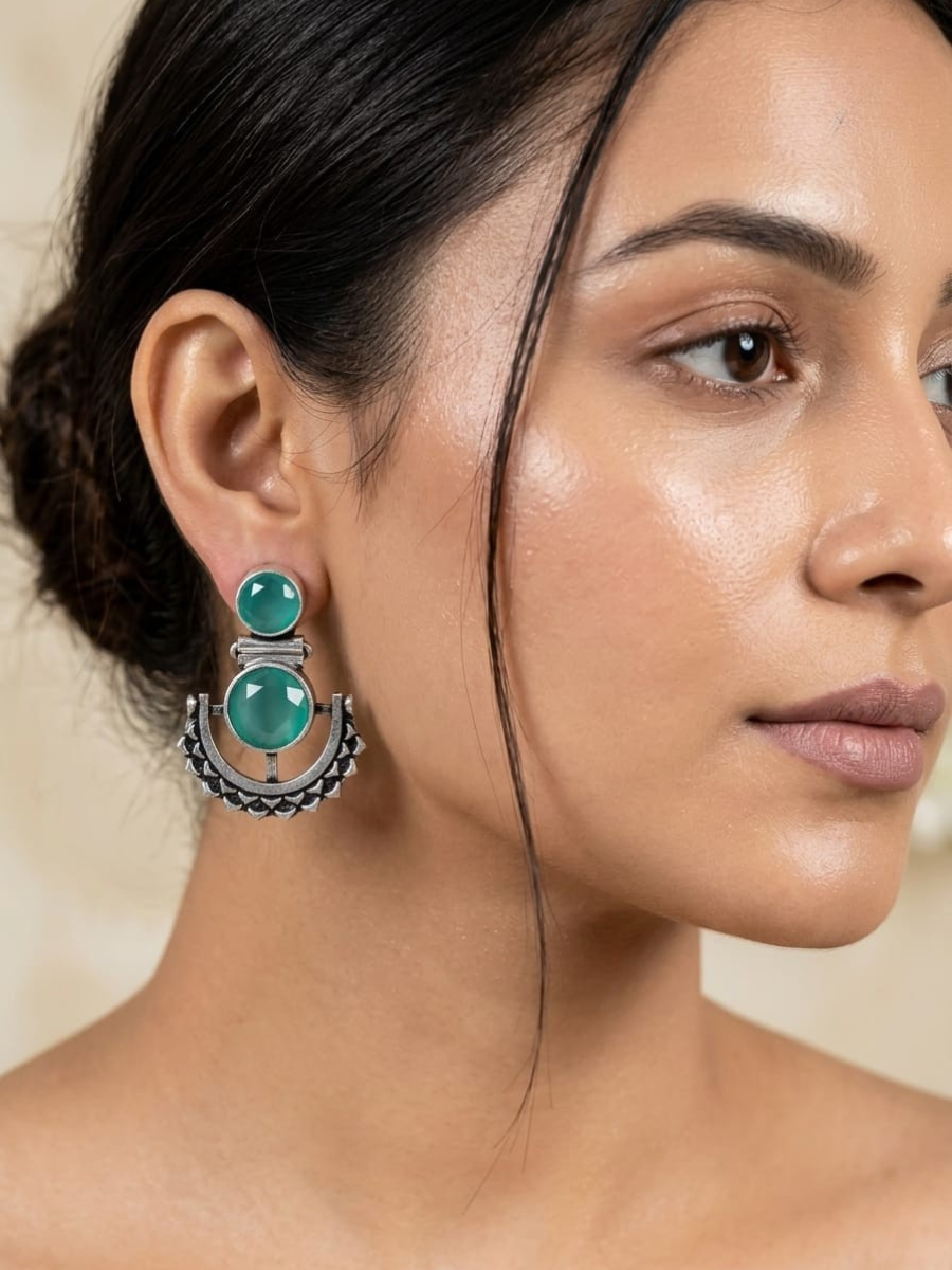 A model is wearing our Sea Green Stone Studded Oxidised Silver Dangler Earrings