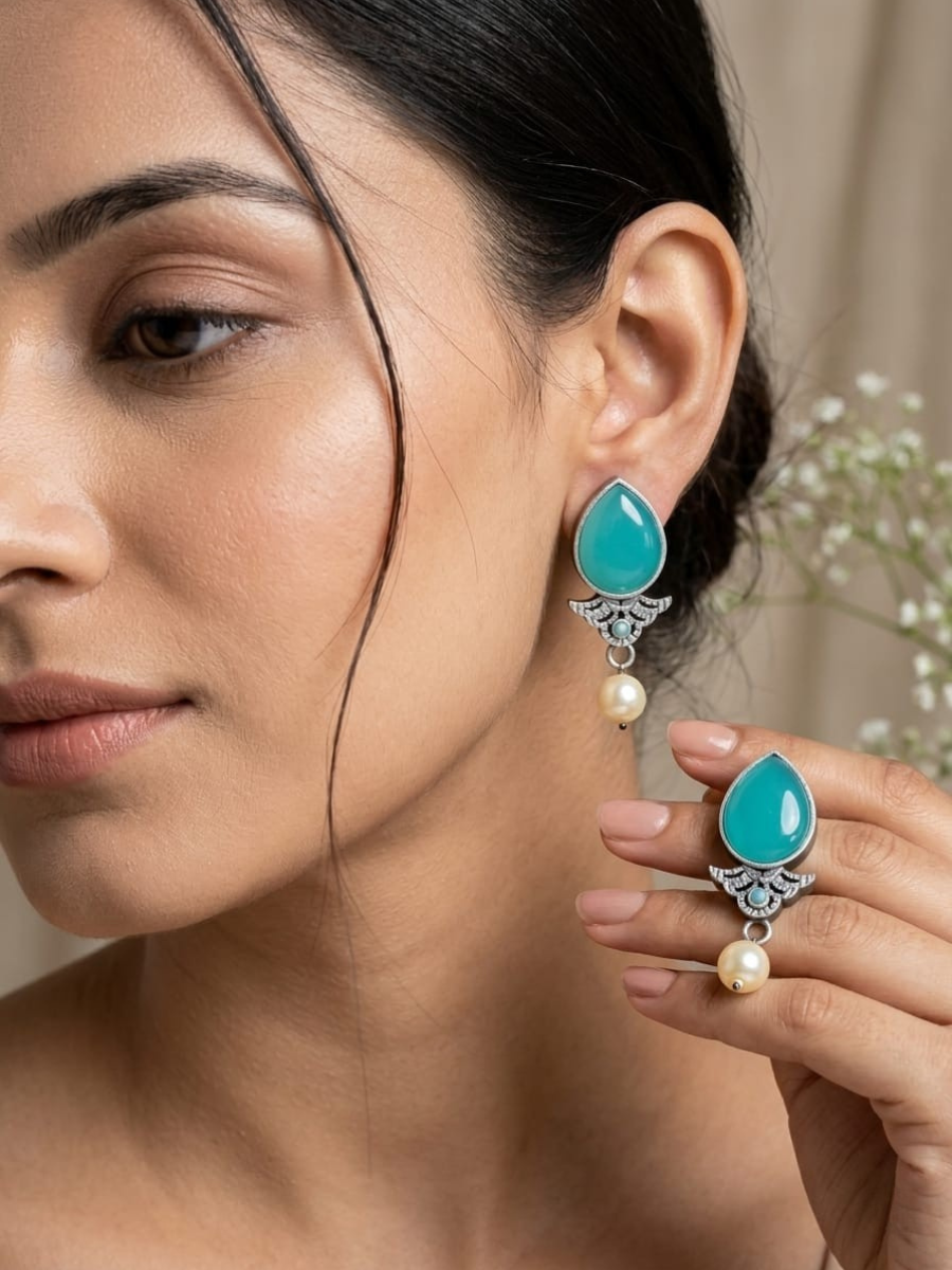 A model is wearing our Sea Green Stone Studded Oxidised Silver Stud Earrings