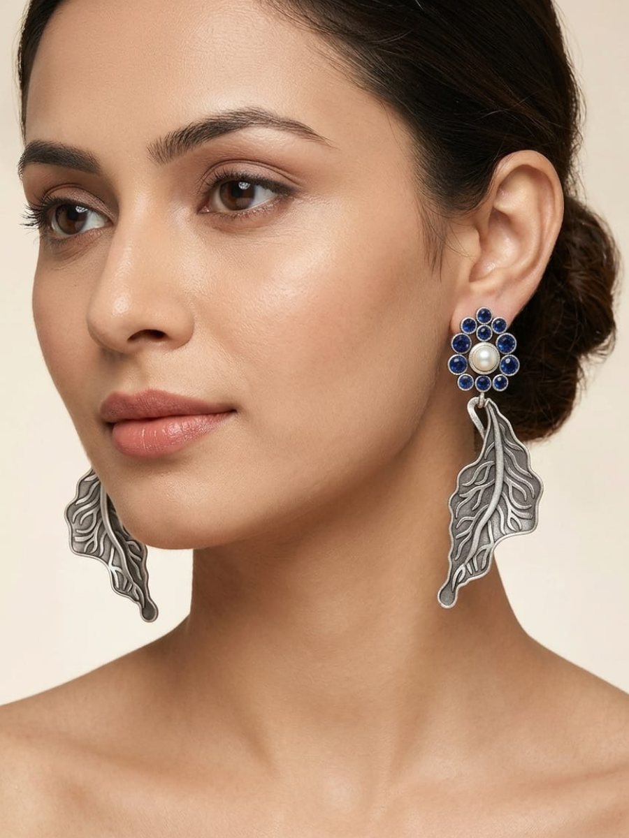 A model is wearing our Silver Oxidised Blue Stones Floral Leaf Drop Earrings