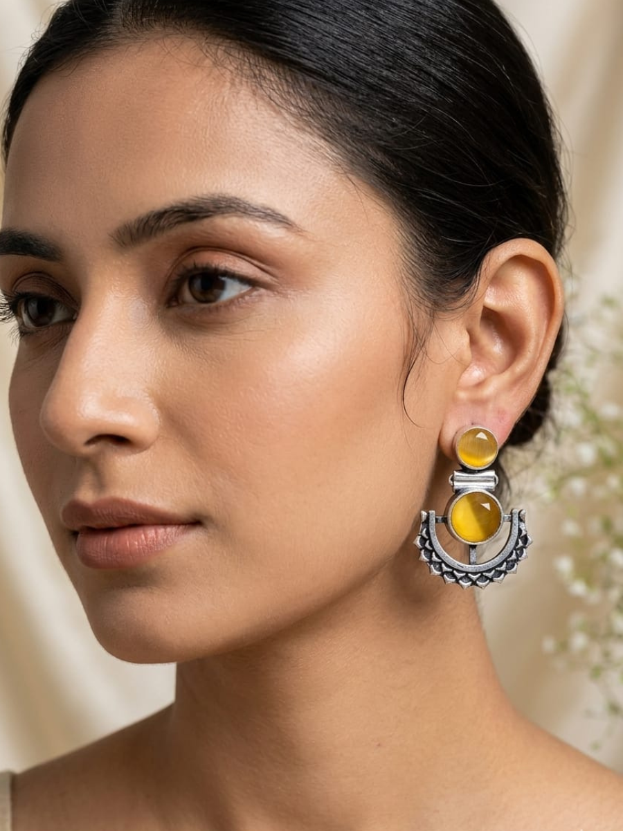 A model is wearing our Yellow Stone Studded Oxidised Silver Dangler Earrings