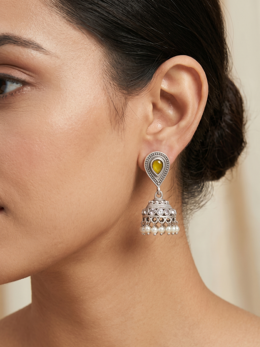 A model is wearing our Yellow Stone Studded Oxidised Silver Small Jhumka Earrings