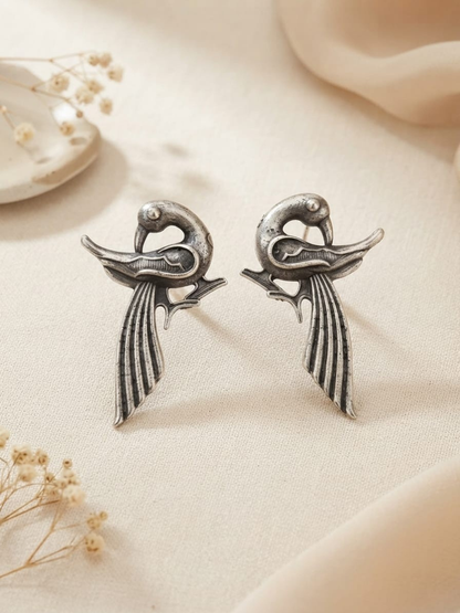 A pair of silver-toned bird stud earrings with long feather-like tails