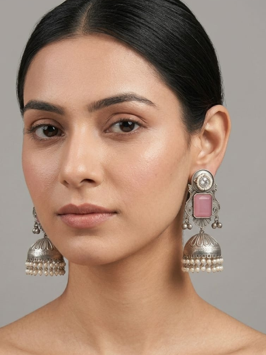 A model is wearing our Baby Pink Stone Studded Big Oxidised Silver Jhumka Earrings
