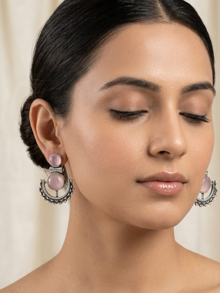 A model is wearing our Baby Pink Stone Studded Oxidised Silver Dangler Earrings