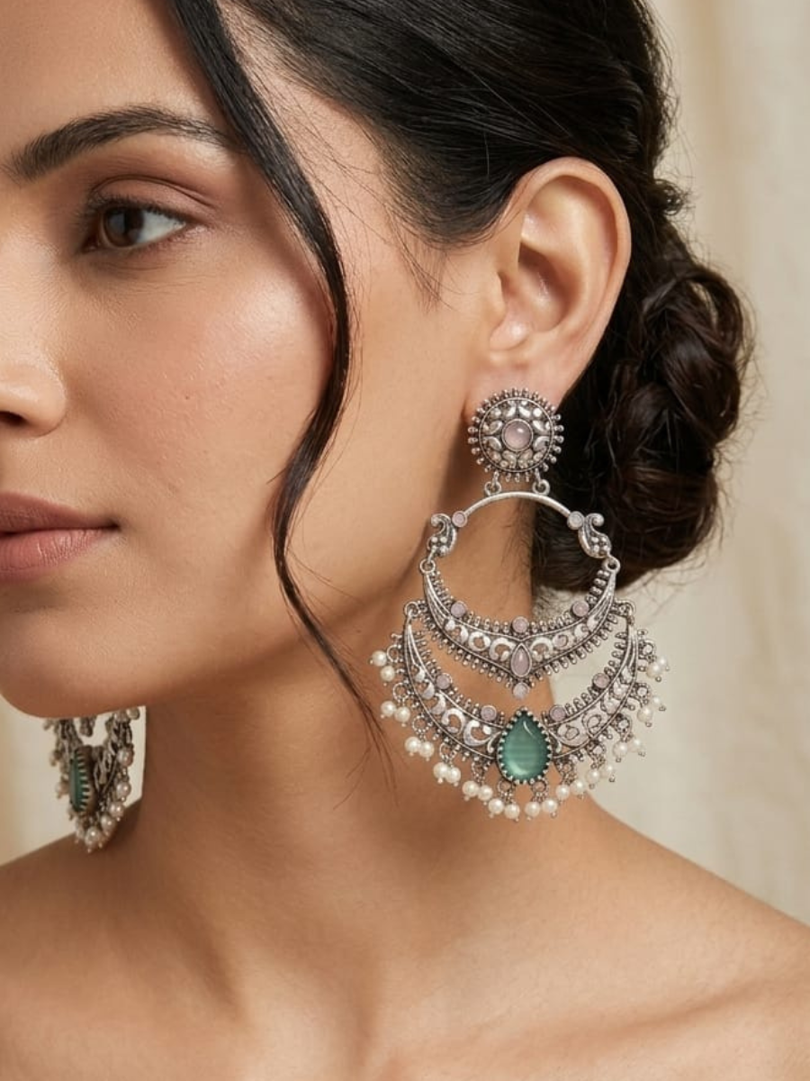 A model is wearing our Baby Pink and Blue Stone German Silver Oxidised Chandbali Earrings