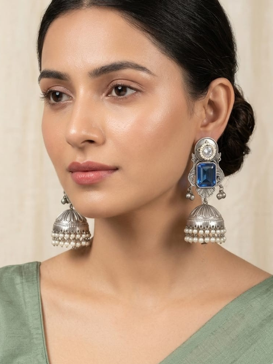 A model is wearing our Blue Stone Studded German Silver Oxidised Big Jhumka Earrings 