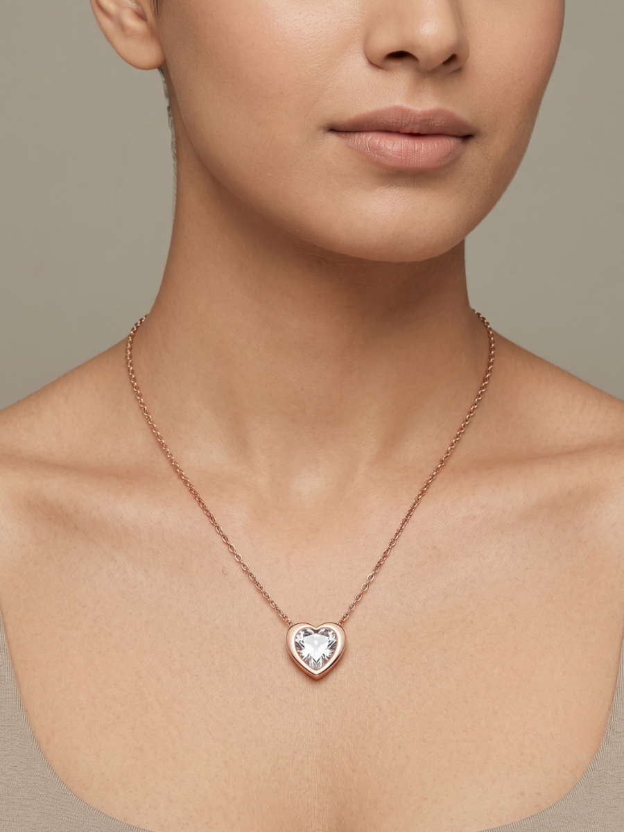 Rose gold necklace with a heart-shaped pendant worn by a model