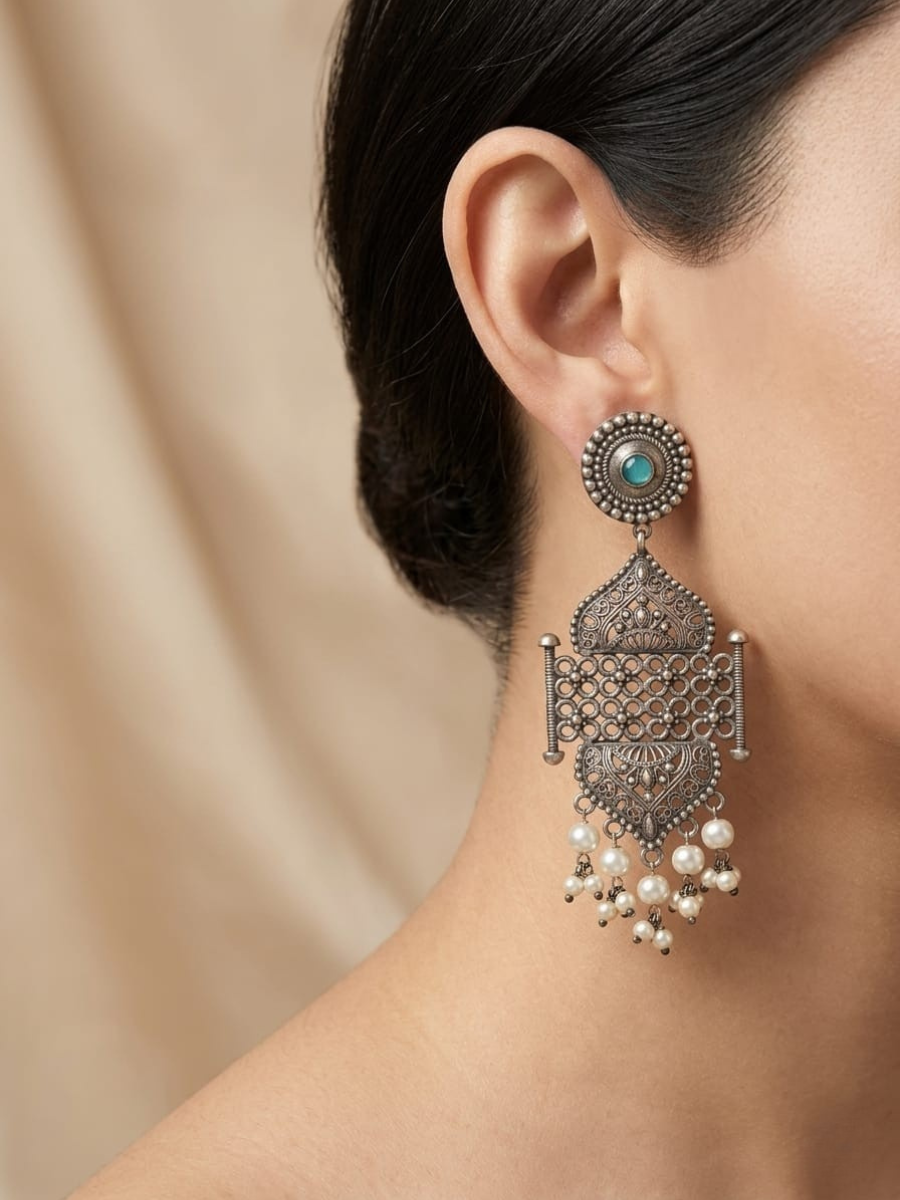A model is wearing our Designer Oxidsied Silver Turquoise Statement Earrings