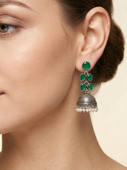 A model is wearing our Elegant Green Stones Oxidised Silver Drop Jhumka Earrings