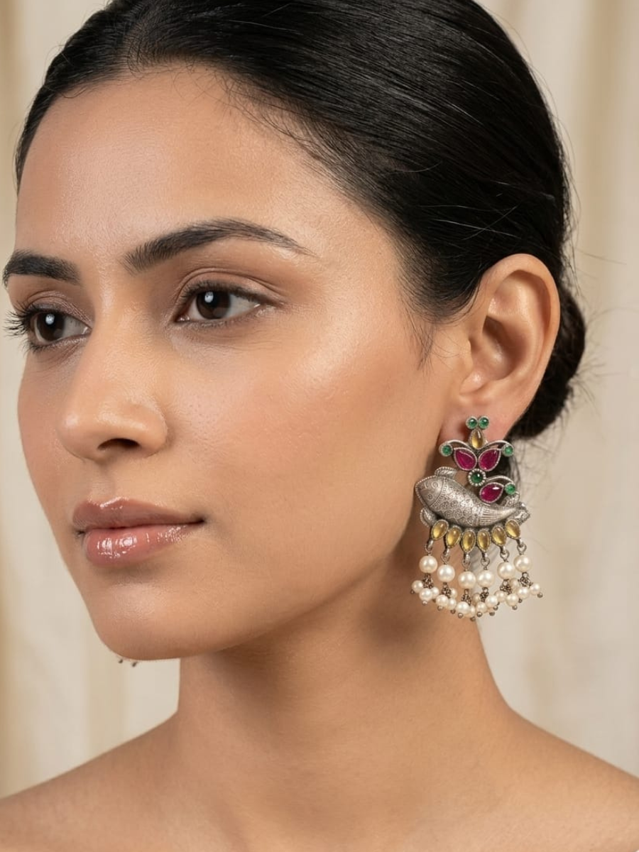 A model is wearing our Ethnic Yellow and Pink Fish Motif Oxidised Silver Earrings