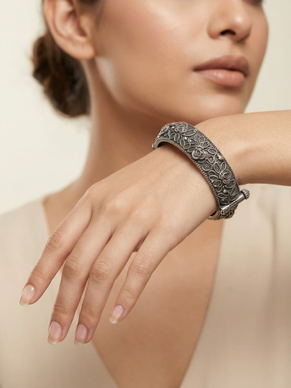 A model is wearing our Flower Style German Silver Oxidised Thin Kada Bangle
