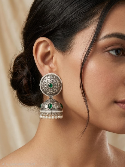 A model wearing our Green Stone German Silver Oxidised Jhumka Earrings