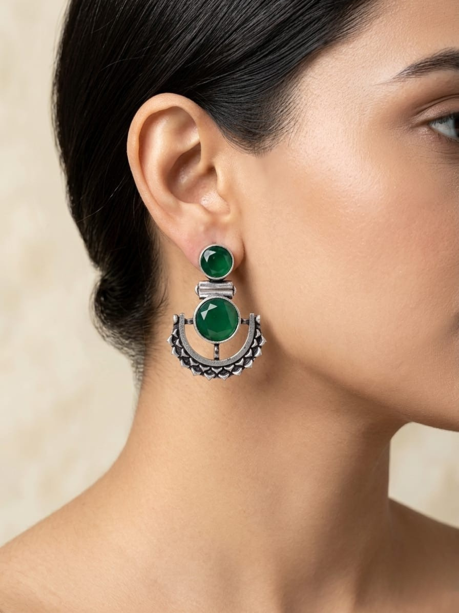 A model is wearing our Green Stone Studded Oxidised Silver Dangler Earrings
