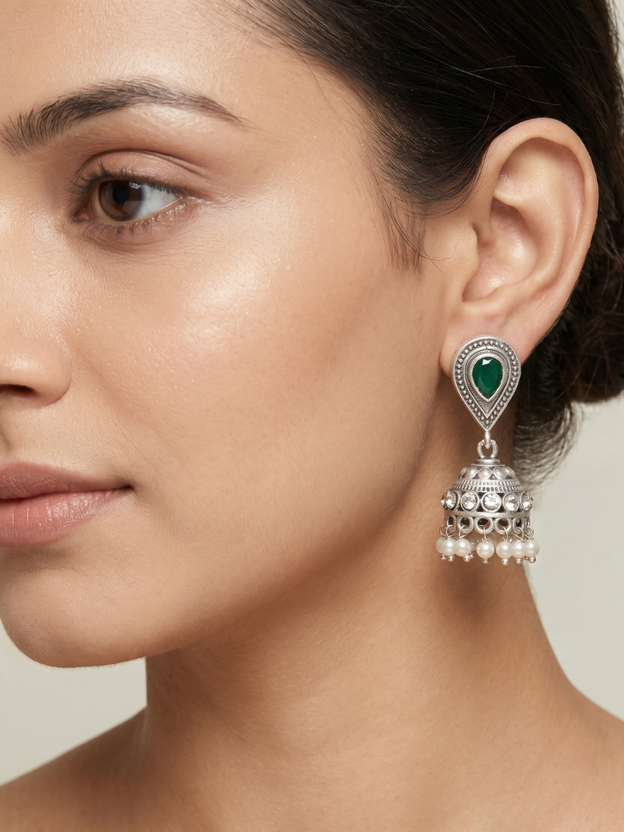 A model is wearing our Green Stone Studded Oxidised Silver Small Jhumka Earrings