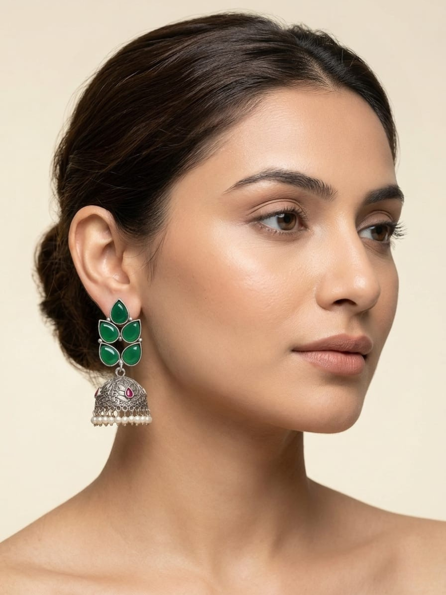A model is wearing our Green and Red Leaf Shaped Big Oxidised Silver Jhumka Earrings