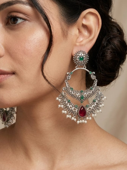 A model is wearing our Green and Ruby Red Stones German Silver Oxidised Chandbali Earrings