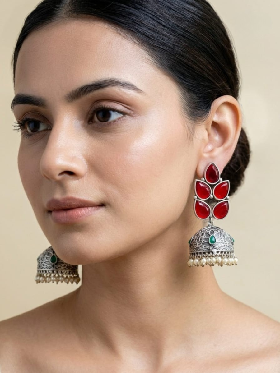 A model is wearing our Leaf Shaped Ruby Red Stones Big Oxidised Silver Jhumka Earrings