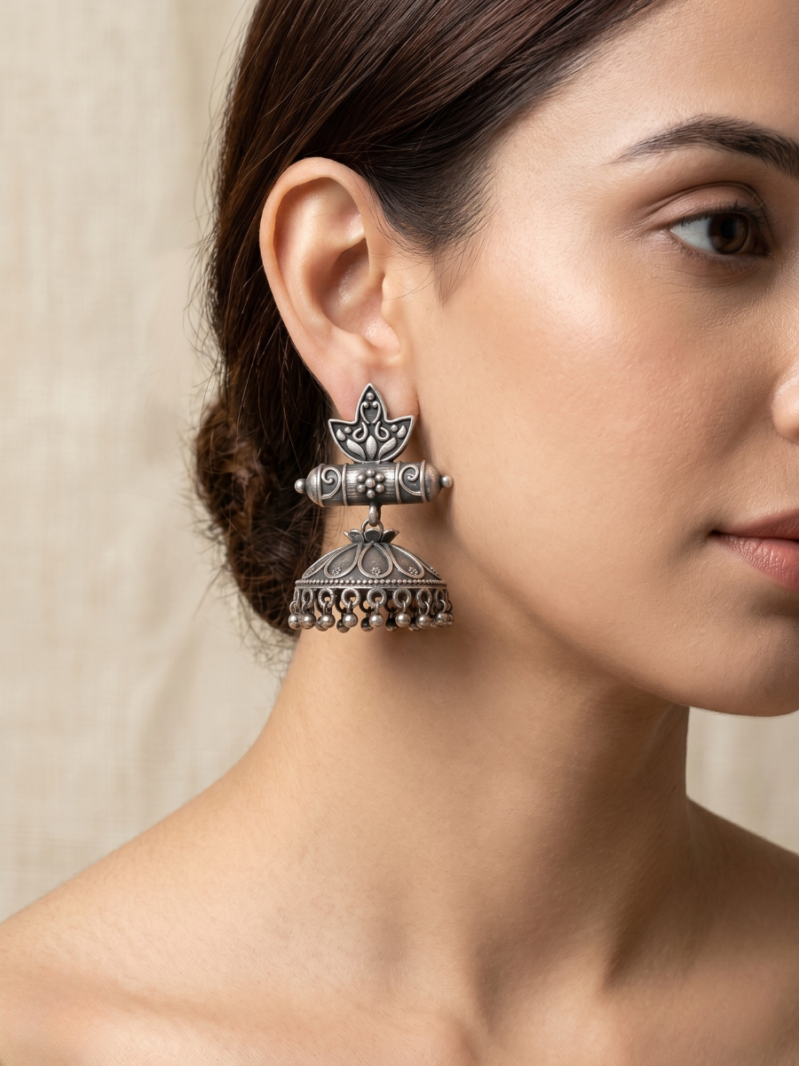 A model is wearing our Lotus Bloom Style German Silver Oxidised Jhumka Earrings