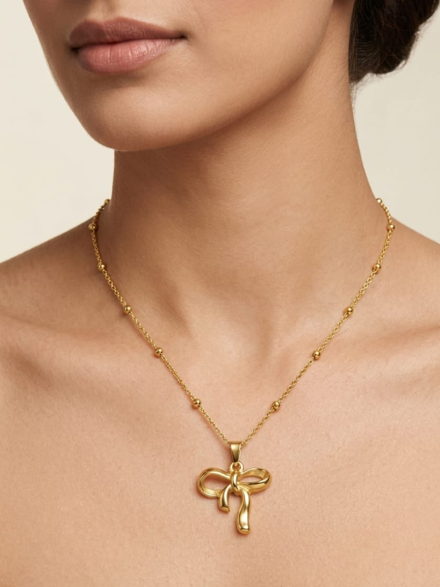 A person is wearing our Mini Ribbon Bow Golden Plated Beads Chain Necklace