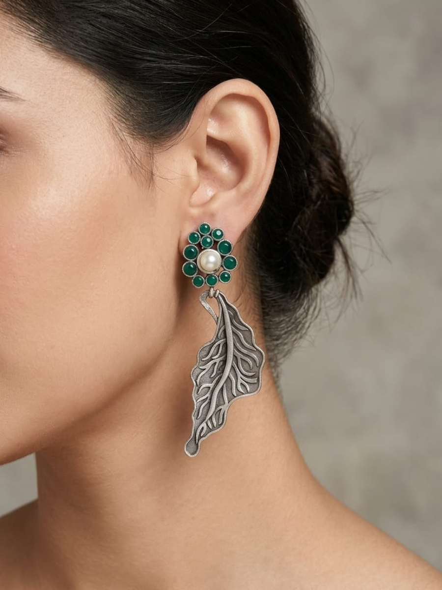 A model is wearing our Oxidised Silver Green Leaf Drop Statement Earrings