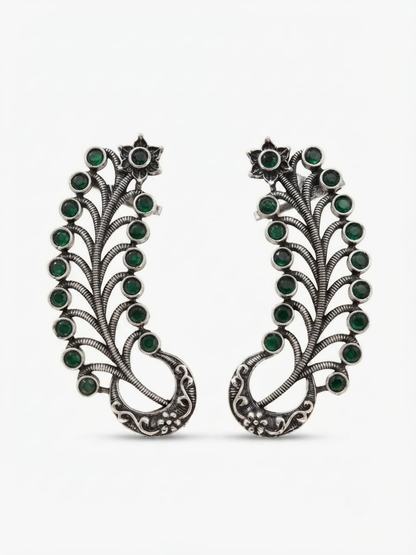 A pair of earcuff earrings decorated with multiple round green gemstones