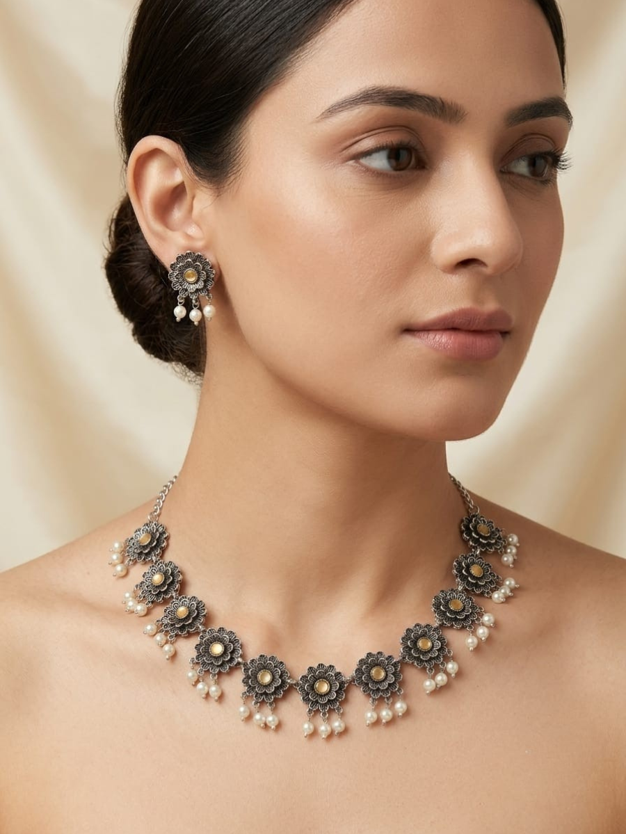 A model is wearing our Peach Flower Shaped Oxidised Silver Necklace Set with Earrings