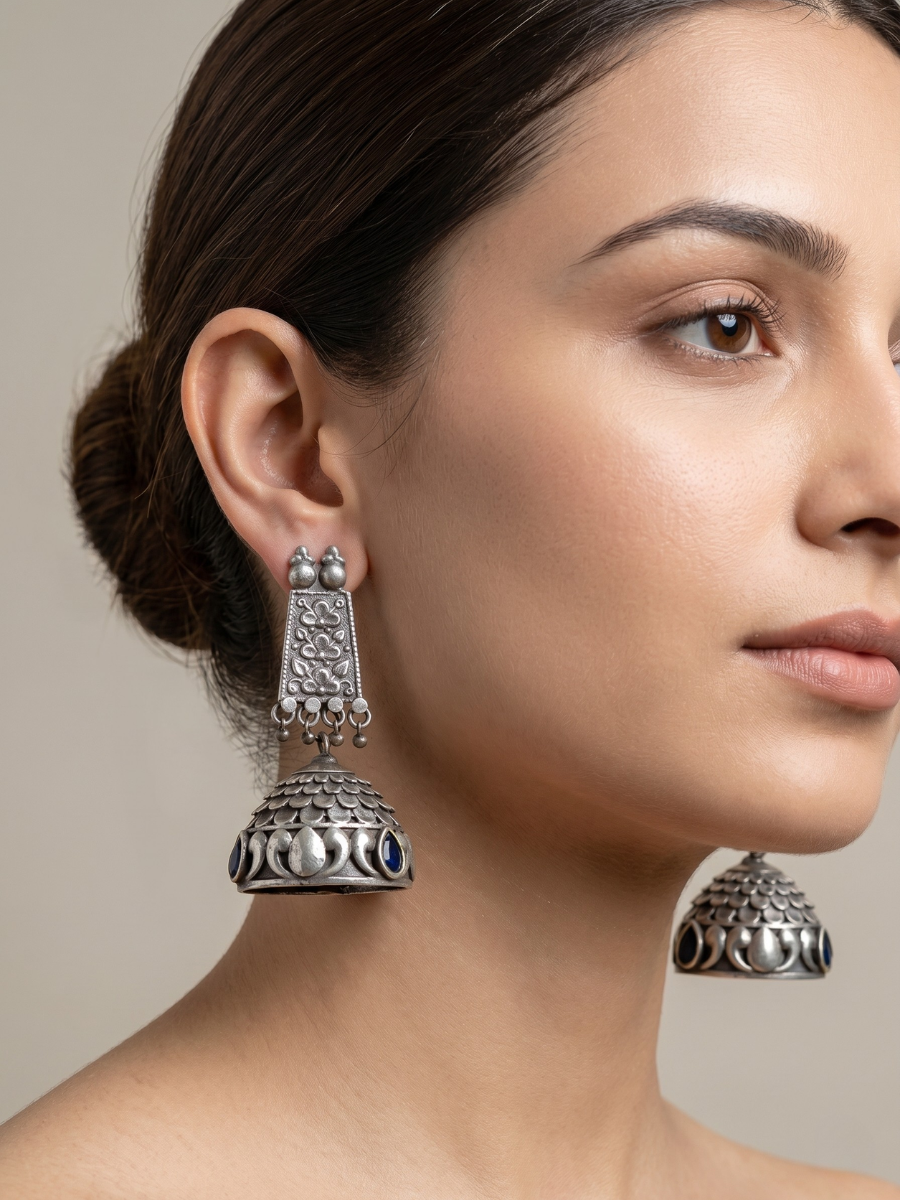 A model is wearing our Premium Blue Stones German Silver Oxidised Jhumka Earrings