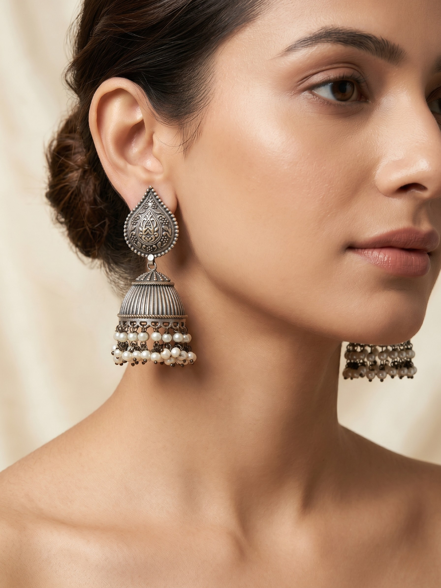 A model is wearing our Premium Pearl Drops German Silver Oxidised Jhumka Earrings