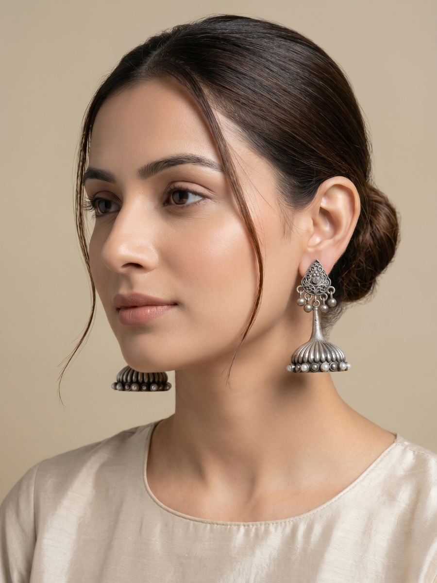 A model is wearing our Premium Pearl Studded German Silver Oxidised Small Jhumka Earrings