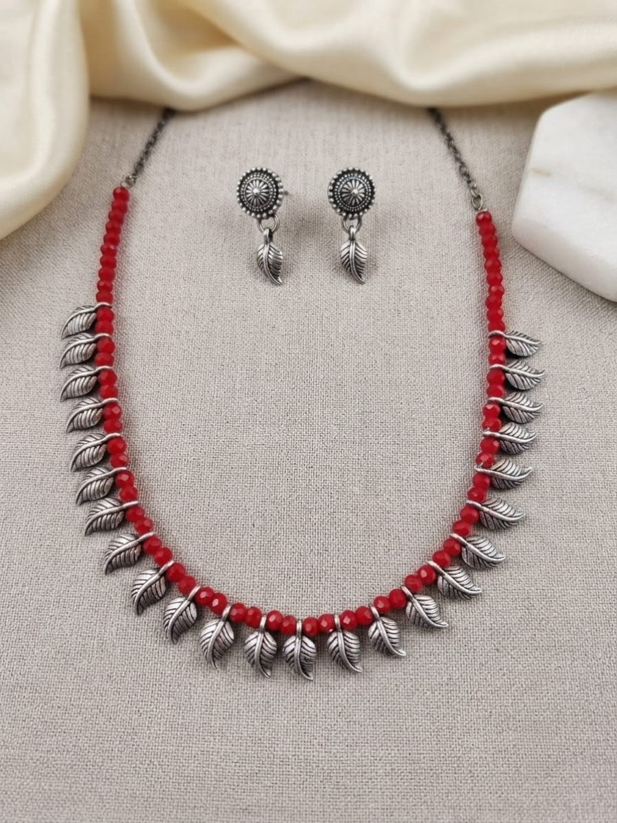 A red and silver jewelry set featuring a necklace and matching earrings
