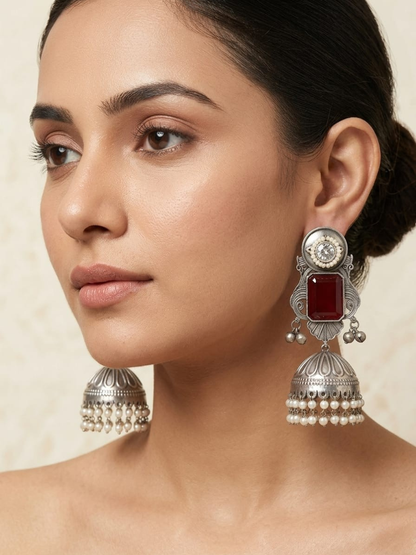 A model is wearing our Ruby Red Stone Studded German Silver Oxidised Big Jhumka Earrings
