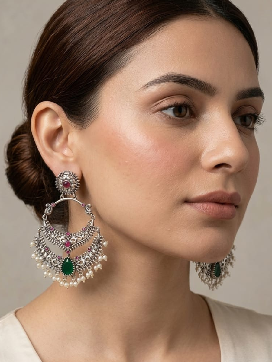 A model is wearing our Ruby Red and Green Stone German Silver Oxidised Chandbali Earrings