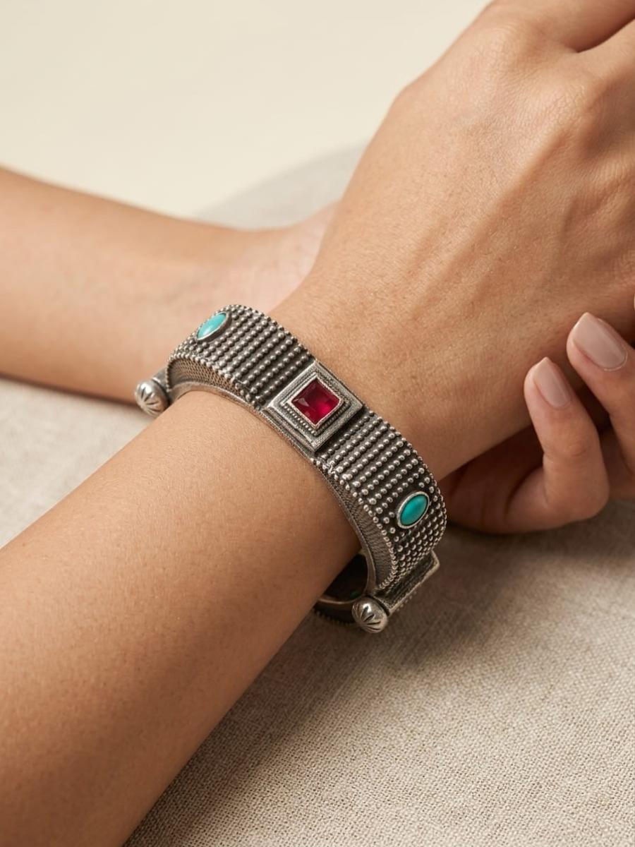 A model is wearing our Ruby Red and Sea Green German Silver Oxidised Square Kada Bracelet