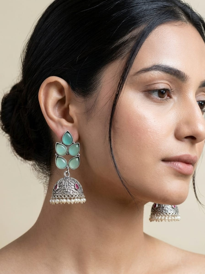 A model is wearing our Sea Green Stones Leaf Shaped Big Oxidised Silver Jhumka Earrings