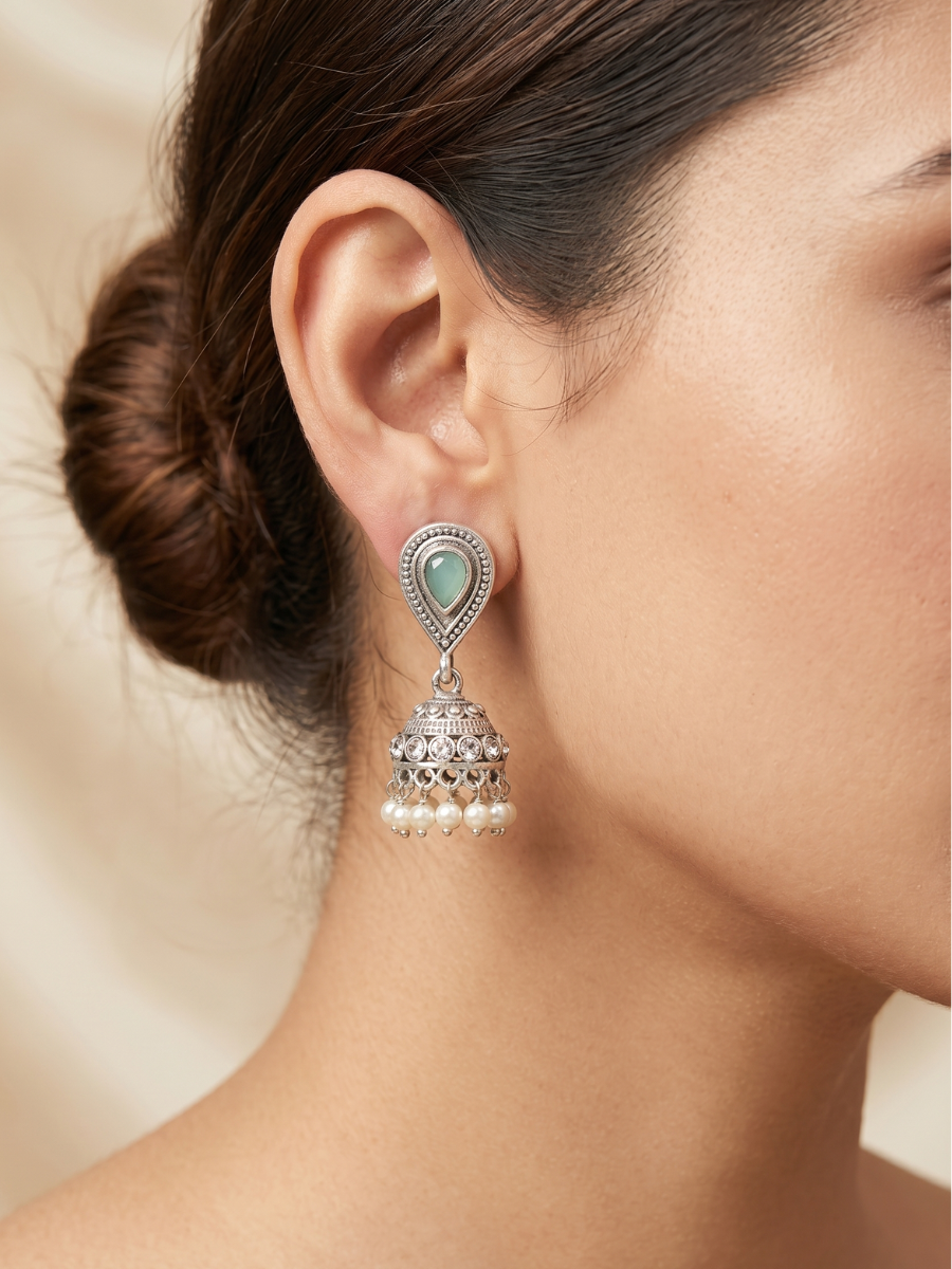 A model is wearing our Sky Blue Stone Studded Oxidised Silver Small Jhumka Earrings