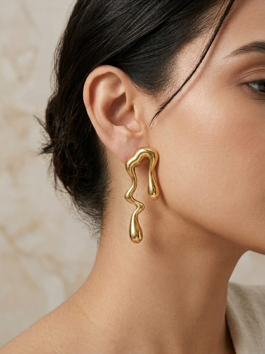 A model is wearing our Stylish Irregular Shaped Water Droplet Golden Earrings