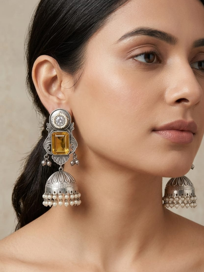 A model is wearing our Yellow Stone Studded Big Oxidised Silver Jhumka Earrings