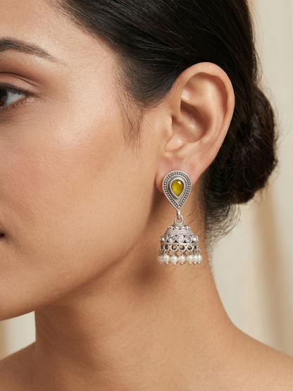 A model is wearing our Yellow Stone Studded Oxidised Silver Small Jhumka Earrings